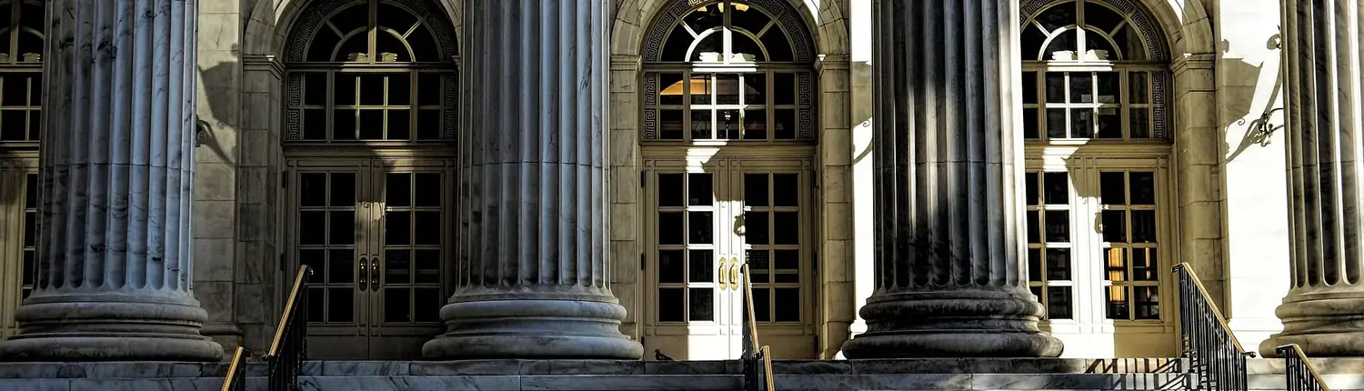 Marble columns and tall doorways of a classical courthouse entrance
